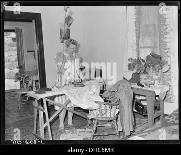 Mrs. Irving Bittick, ironing in living room of her home in company housing project. Independent Coal & Coke Company... 540522 Stock Photo