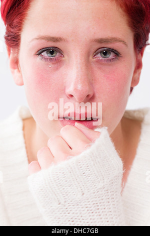 sadly depressed crying young redhead woman with tears in her eyes Stock Photo