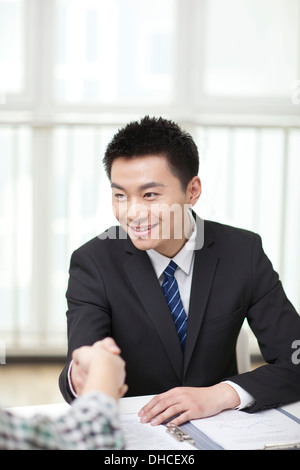 Portrait of young businessman executives extending hands to shake Stock Photo