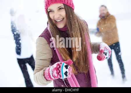 Portrait of happy girl in winterwear laughing while playing with her friends outside Stock Photo