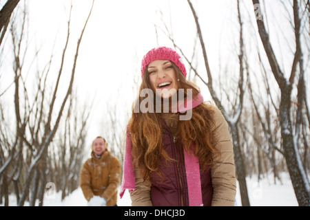 Portrait of happy girl in winterwear laughing on background of her boyfriend outside Stock Photo