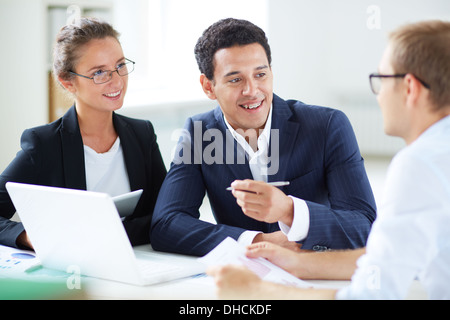 Portrait of smart business partners looking at their colleague during discussion Stock Photo