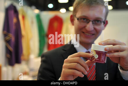 Augsburg, Germany. 07th Nov, 2013. Daniel Dabrowski holds gluten-free communion wafers at a booth at the church trade fair 'Gloria' in Augsburg, Germany, 07 November 2013. The fair which features products around the church runs until 09 November 2013. Photo: STEFAN PUCHNER/dpa/Alamy Live News Stock Photo