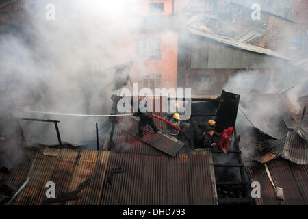 Srinagar, Indian Administered Kashmir 07th November 2013. Fire tenders try to douse a fire in  Srinagar, the summer capital of Indian administered Kashmir. Three residential houses were gutted in a fire at the Maharaja Bazar locality in the heart of Srinagar .  (Sofi Suhail/ Alamy Live News) Stock Photo