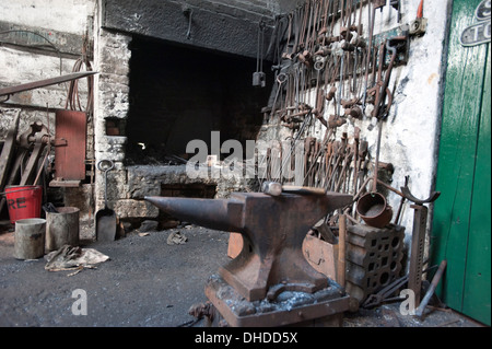 A Blacksmith's anvil and a range of tools hanging by the forge in in the Marley Hill engine shed, Europes oldest working Engine shed, built in 1854, on the Tanfield Railway, County Durham Stock Photo