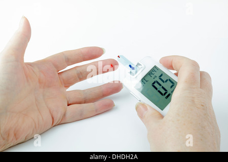 Diabetic blood glucose test - blood on finger tip and meter strip Stock Photo