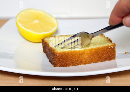 Slice of home made lemon cake on plate with lemon half Stock Photo