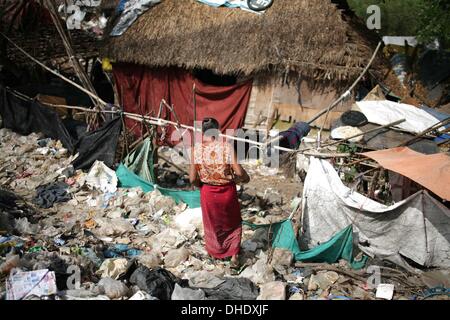 Mae Sot, Tak, Thailand. 7th Nov, 2013. A Burmese lady and her house at the Mae Sot garbage dump. Tingkaya also known as the City Of Garbage an area roughly the size of a football stadium The poor inhabitants make a living selling recyclable materials like wire, metal, glass, plastic. They heap dwellers survive by eating left-overs and sleep in the same harsh environment which is a breeding ground for bacteria and diseases. Credit:  Rohan Radheya/ZUMA Wire/ZUMAPRESS.com/Alamy Live News Stock Photo