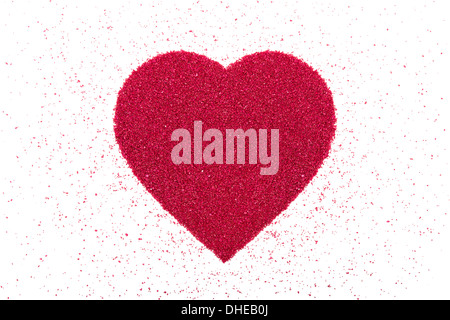 Heart made of decorative red sand is on a white background. Stock Photo