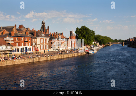 People sitting along Kings Staith by the River Ouse on a summer evening, City of York, Yorkshire, England, United Kingdom Stock Photo