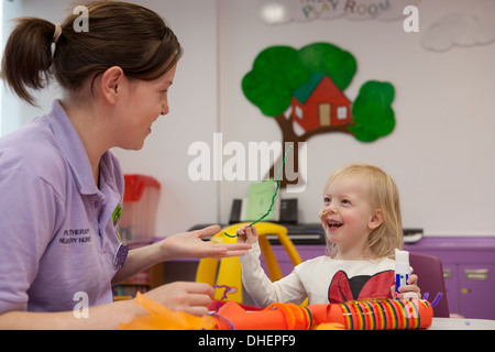 A young girl enjoys the playroom at a hospital UK Stock Photo