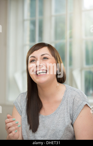 Young woman looking up and laughing Stock Photo