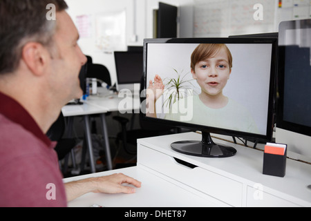 Man sitting at desk having video call with son Stock Photo
