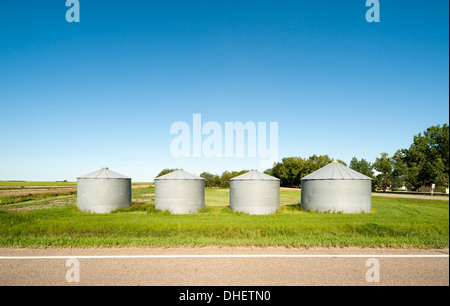 Four grain silos on an empty road Stock Photo