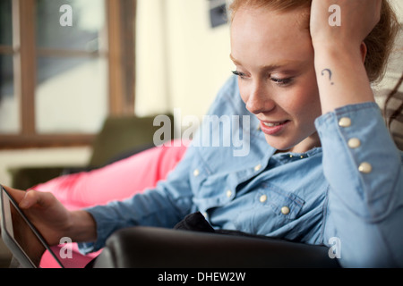 Young woman with question mark tattoo using digital tablet Stock Photo
