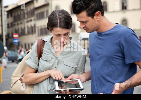 Young couple using digital tablet, Florence, Tuscany, Italy Stock Photo