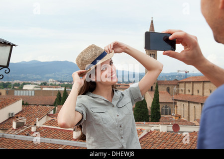 Man photographing woman with smartphone, Florence, Tuscany, Italy Stock Photo