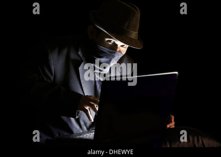 Masked man stealing sensitive information Stock Photo