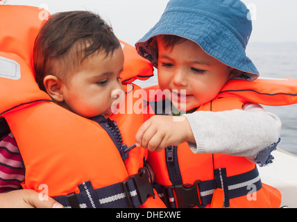 Boy zipping baby's life jacket Stock Photo