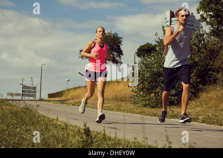 Young couple jogging down urban path Stock Photo