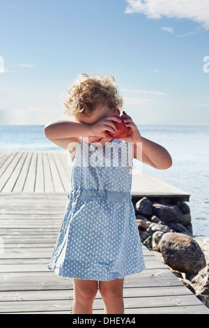 Portrait of female toddler with red apple, Utvalnas, Gavle, Sweden Stock Photo