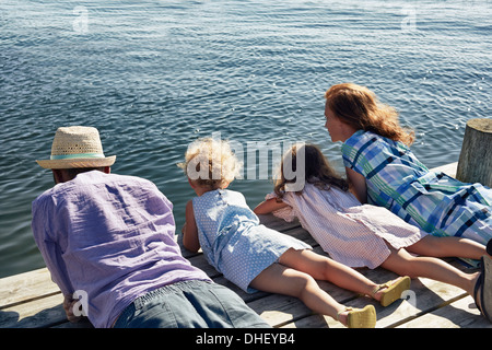 Parents and daughters lying on pier, Utvalnas, Gavle, Sweden Stock Photo