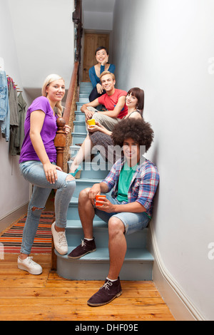 Portrait of flatmates sitting on stairs Stock Photo