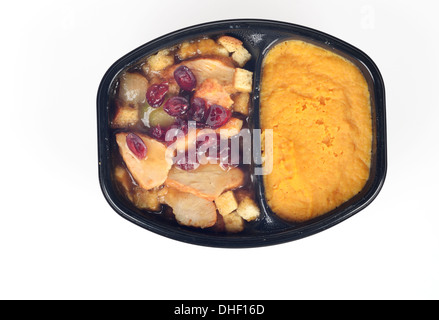 Microwave cooked hot tv dinner of turkey, stuffing, cranberries and gravy with butternut squash isolated on white background Stock Photo
