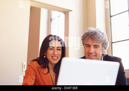 Mature businessman and woman using laptop Stock Photo