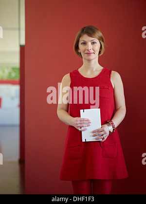 Portrait of office worker wearing red dress Stock Photo