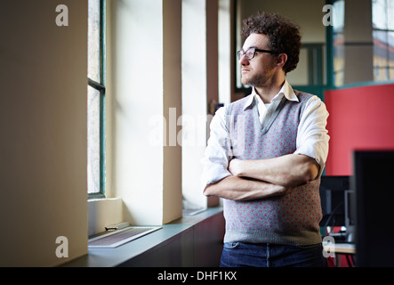 Mid adult man looking out of window Stock Photo