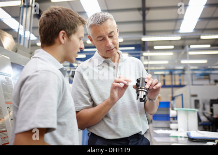 Manager and working looking at component in engineering factory Stock Photo