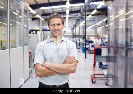 Portrait of worker with arms folded in engineering factory Stock Photo