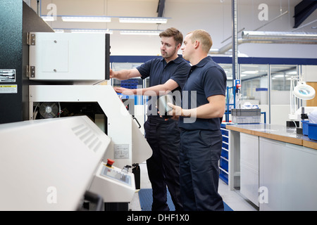 Workers checking control panel in engineering factory Stock Photo
