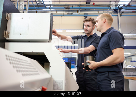 Workers checking looking at control panel in engineering factory Stock Photo