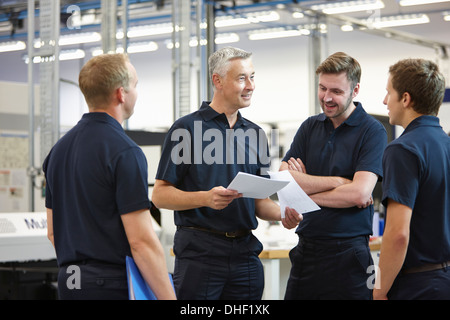 Manager and workers discussing paperwork in engineering factory Stock Photo