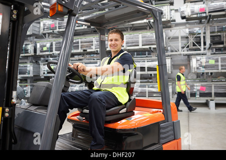 Forklift truck driver in engineering warehouse Stock Photo