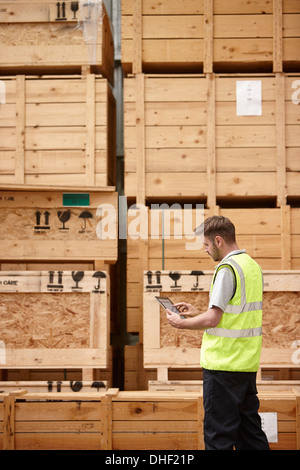 Warehouse worker checking crates in engineering warehouse Stock Photo