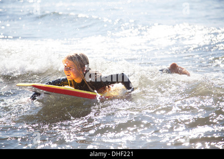 Portrait of girl on surfboard, Wales, UK Stock Photo