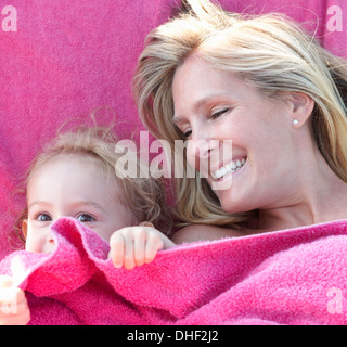 Portrait of mother and daughter wrapped in pink towel Stock Photo