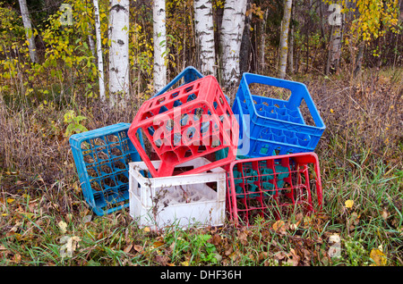 plastic boxes from beer bottles in autumn forest. nature pollution concept Stock Photo
