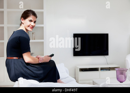 Young woman wearing black dress in living room Stock Photo