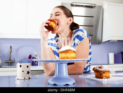 Young woman eating muffin Stock Photo