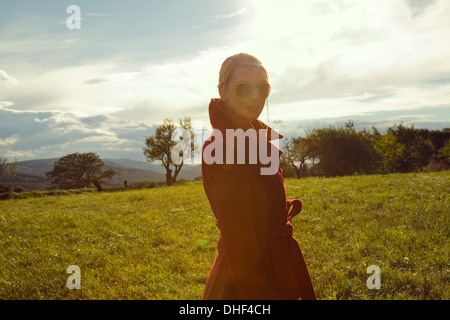 Young woman in field posing in sunglasses Stock Photo