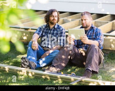Manual Workers Using Digital Tablet At Construction Site Stock Photo