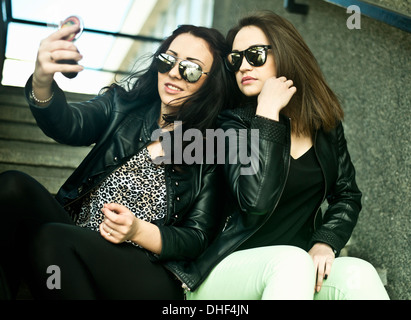 Two young woman making self portrait on mobile phone Stock Photo