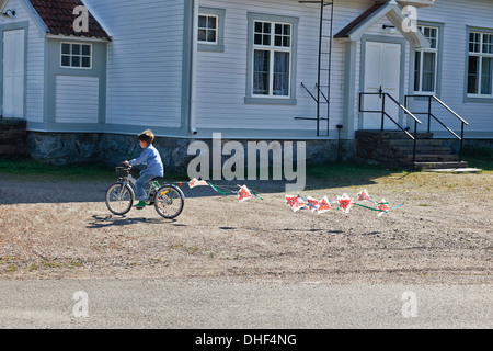 Boy riding bicycle pulling bunting Stock Photo