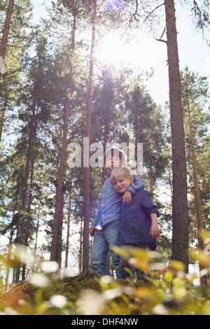 Brothers standing in forest with arm around Stock Photo