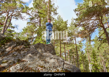 Boy standing on top of rock Stock Photo