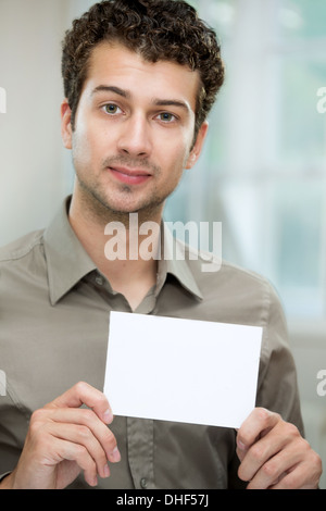 Young man holding white card Stock Photo